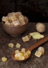 Closeup view of candied ginger in a bowl and on a wooden spoon — Stock Photo