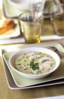 Сливочный грибной суп на белой тарелке над тарелками на столе — стоковое фото