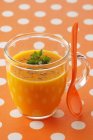 Морквяний суп у скляній чашці з ложкою — стокове фото