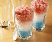 Vista close-up de bebidas frutadas em camadas congeladas em copos — Fotografia de Stock