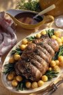 Roast haunch of venison without bone and pepper sauce on white plate — Stock Photo