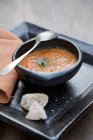 Carrot soup in black bowl — Stock Photo