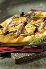 Pissaladiere on cloth with knife — Stock Photo