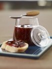 Fig jam in jar with piece of bread — Stock Photo