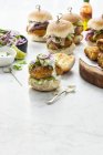 Fish Sliders with pickled cucumber and red onion on white surface — Stock Photo