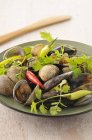 Shellfish with ginger and pimentos on green plate — Stock Photo