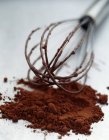 Schokoladenpulver und Schneebesen — Stockfoto