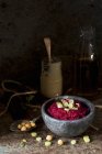 Hummus di barbabietola rossa in ciotola nera su superficie di legno — Foto stock