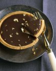 Dark chocolate tartlet with gold flakes — Stock Photo