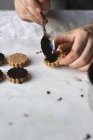 Vue rapprochée de la personne qui cuisine des biscuits à l'avoine végétalien crus avec glaçage au chocolat — Photo de stock