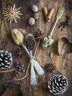 Vista dall'alto di diverse spezie con cucchiai, coni e tagliabiscotti a forma di cuore su sfondo di legno — Foto stock