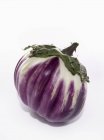 Round purple eggplant on white surface — Stock Photo