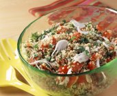 Tabbouleh being mixed in glass bowl — Stock Photo