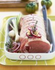 Joint of fresh raw pork with vegetables — Stock Photo
