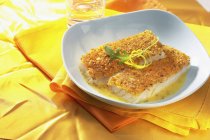 Fish la bordelaise auf weißem Teller über gelben Handtüchern — Stockfoto