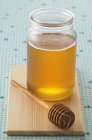 Pote de mel e colher de madeira — Fotografia de Stock