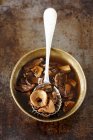Top view of cooked mushrooms with spoon in bowl — Stock Photo
