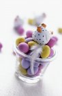 Vue rapprochée de mini oeufs de Pâques en verre avec figurine de poule et plume — Photo de stock