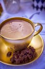 Hot chocolate in gold cup — Stock Photo