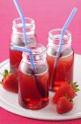Small bottles of strawberry cordial — Stock Photo