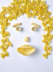 Face made of dry uncooked pasta — Stock Photo