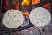 Vista da vicino di due tortillas su una grata di fuoco — Foto stock