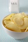 Potato crisps in white bowl — Stock Photo
