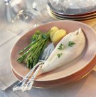 Closeup view of John Dory fillets with green asparagus — Stock Photo