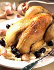 Guinea fowl with black olives  on white plate with fork — Stock Photo