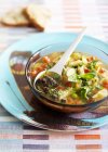 Minestrone in glass bowl with spoon — Stock Photo