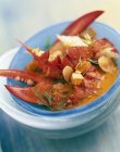Closeup view of lobster soup with curry and dried fruit — Stock Photo