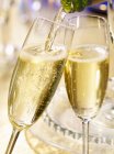 Champagne glasses and pouring champagne — Stock Photo