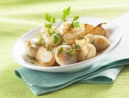 Sauteed young turnips on white plate over green towel — Stock Photo