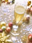 Bicchiere di champagne e decorazioni natalizie — Foto stock