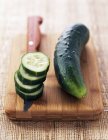 Fresh whole and sliced cucumbers — Stock Photo
