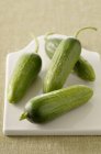 Mini cucumbers on cutting board — Stock Photo
