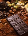 Barretta di cioccolato, caramelle e selezione di noci — Foto stock
