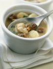 Small casserole dish of scallops and morels in small bowl with spoon — Stock Photo