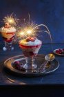 Closeup view of cranberry trifle with berries and burning sparklers — Stock Photo
