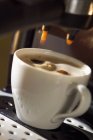 Tasse Kaffee unter Espressomaschine — Stockfoto