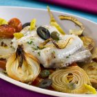 Sea bass with vegetables  on white plate — Stock Photo