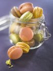 Macroons in a glass jar over dark surface — Stock Photo