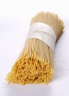 Closeup view of thin spaghetti tied with twine — Stock Photo