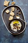 Hummus with black chickpeas and sesame seeds on black plate — Stock Photo