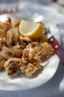 Calamarios fritos en plato blanco con tenedor - foto de stock