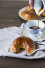 Вид крупным планом на выпечку из грецкого ореха в форме полумесяца с чашкой кофе — стоковое фото