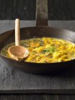 Vista close-up de omelete de ervas com colher na frigideira — Fotografia de Stock