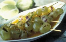 Spiedini d'uva alla griglia con scorza di limone in piatto bianco — Foto stock
