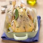Uncooked plucked chicken in oil — Stock Photo