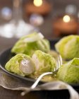 Scallop and cabbage Aumoniere on black plate with fork — Stock Photo
